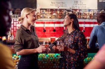 Two Women Meeting For Drinks And Socializing In Bar After Work