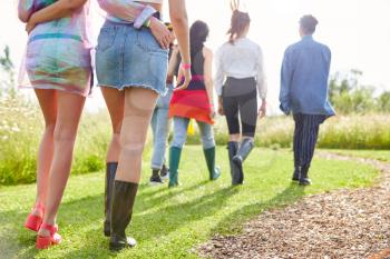Close Up Rear View Of Female Friends Walking Back To Tent After Outdoor Music Festival