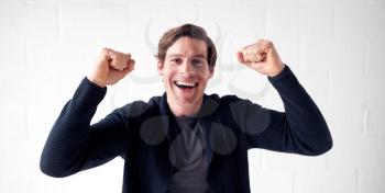 Happy Man Wearing Casual Clothing Celebrating Standing Against White Studio Wall