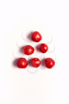 Overhead View Of Individual Fresh Tomatoes On White Background In Pyramid Shape