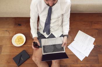 Businessman At End Of Day With Beer Wearing Loungewear And Shirt And Tie On Laptop Working From Home