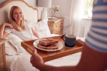 Husband Surprising Wife With Breakfast In Bed At Home