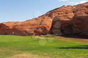 Green lawn and hill from red sandstone. Vicinities of the city of Page in the USA
