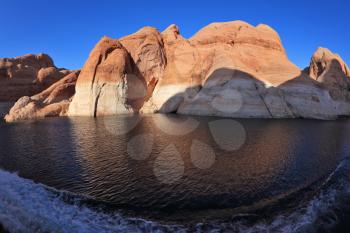 Boat trip along the beautiful Lake Powell. Lakeside in red sandstone covered sunset.