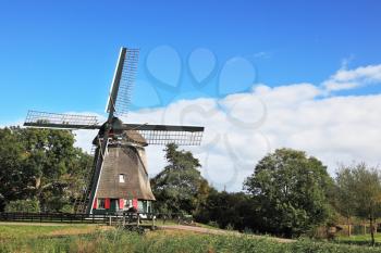 Pastoral landscape in the Netherlands. The windmill on the green hill