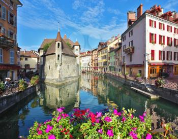 Charming old town of Annecy in Provence. Clear early morning. Bastion- prison turned into  museum, is reflected in the water channel