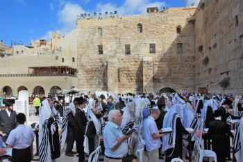 JERUSALEM, ISRAEL - SEPTEMBER 20, 2013:The Western Wall of the Temple in Jerusalem. Morning Sukkot. Many religious Jews in traditional robes tallit gathered for prayer.