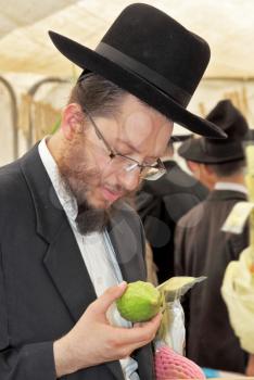 BNEI- BRAK, ISRAEL - SEPTEMBER 17, 2013: Traditional market before the holiday of Sukkot. Religious Jews in black hats and skullcap of carefully selected ritual fruits and plants