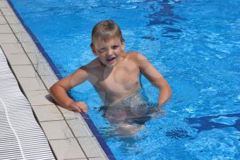  The boy with pleasure bathes in pool with pure transparent water