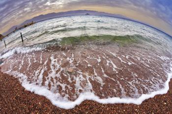Early spring on a beach of Red sea in Israel. The safe place for bathing is fenced. It is photographed by an objective the Fish eye