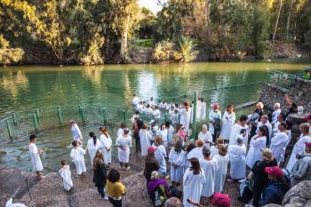 YARDENIT, ISRAEL - JANUARY 21, 2012: Christian pilgrims baptized in the Jordan River. They enter the water, dressed in special white shirt