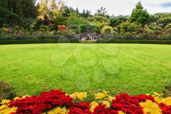 Picturesque ornamental park-garden Butchart Gardens on Vancouver Island, Canada. Green grass lawn and flower beds