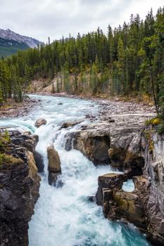  The concept of extreme tourism. Great Sanvapta Falls in Jasper National Park. Autumn trip to Canada