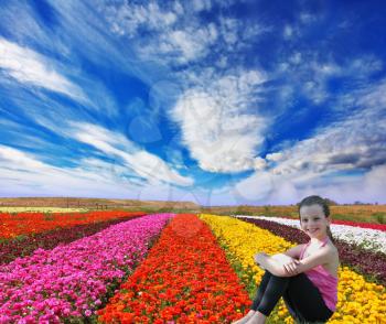 Very beautiful bright colorful flower fields. Among the flowers charming smiling little girl. Commercial cultivation of flowers for sale abroad. 