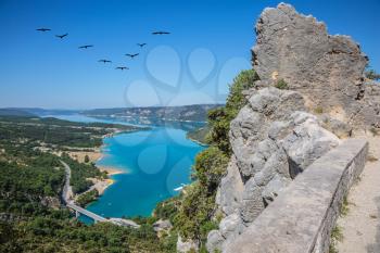 Canyon of Verdon, Provence, May. Bridge on the lake with turquoise water.  The migrating cranes over lake