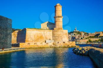 The big watchtower is reflected in blue water of the Marseilles port. Saint Ioann's fort