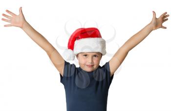 The charming seven-year-old boy in red Santa Claus's cap smiles, having stretched hands up. The photo is executed by isolated