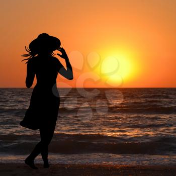 Woman with hat looking at sunrise