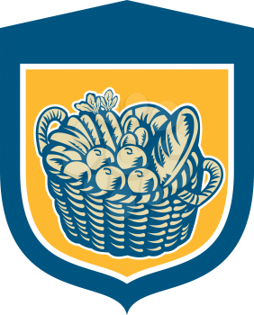 Illustration of a wicker basket full of crop harvest field with festive fruits, vegetables and bread set inside shield crest done in retro woodcut style on isolated background.