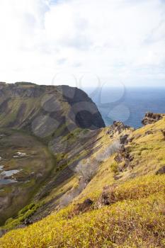 Dramatic Volcano crater near Orongo vilage, Easter Island, grassy walls, sharp rocks, endless ocean