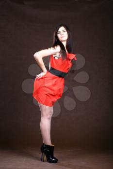 sexy slim woman in red Vintage dress on brown background