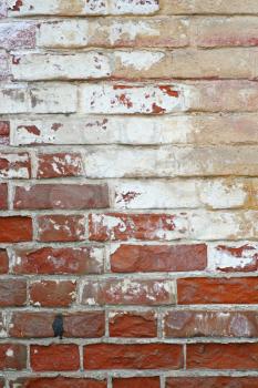 old red brick wall with some traces of former paint jobs