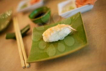 mouth-watering sushi of shrimp on green plate