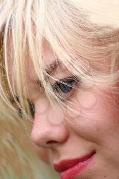 A stunningly beautiful young blond woman with red flower in hair