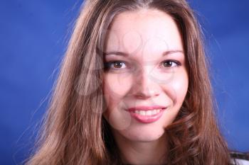 face of young beautiful woman enjoying on blue background