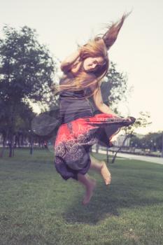 Girl jumping like flying bird. Hair by the wind.