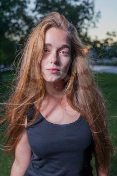 Sad 20s female outside close-up image. Portrait of a beautiful young 20s women in the park in evening.