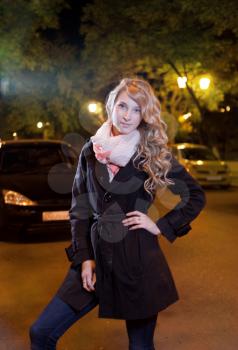 Young blond woman walking on the street, looking at camera
