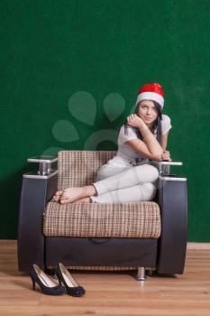 happy mrs. Santa sitting indoor on armchair