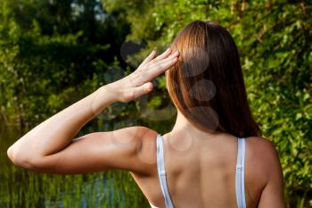 Biceps straining. Back side of the female outdoors in summer time