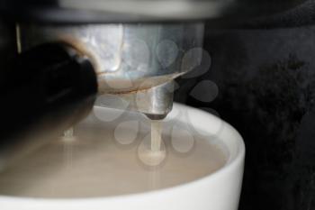 coffee preparation. Coffee is pouring in cup macro shot