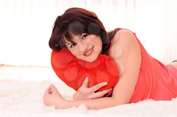 smiling woman with a red heart is on the floor