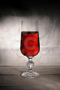 Wineglass with red wine on the dark background