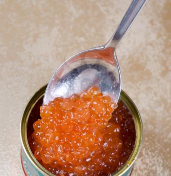 Canned salmon red caviar with spoon closeup