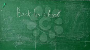 Green chalk blackboard written Back To School with white chalk