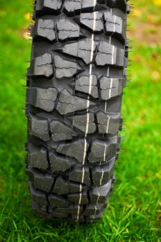 Tire at green grass background