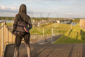 A woman in sportswear on evening city background