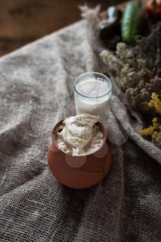 Organic milk and sour cream in vintage dish on rustic background