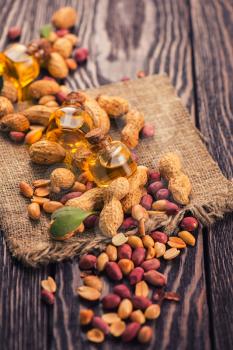 Natural peanuts with oil in a glass jar on the wooden background