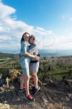 A child embraces mom in the mountain trip. Domestic tourism, travel, lesure and freedom. Altai mountain, beauty summer evening landcape