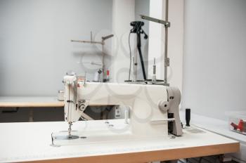 Industrial sewing machine in tailor's workshop