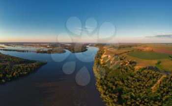 Aerial drone view of river landscape in sunny summer sunset. Top view of siberian Ob river from high attitude in summer sunset. Panorama, bird's eye view