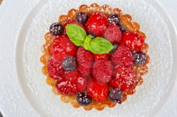 Cake with fresh berries and mint closeup