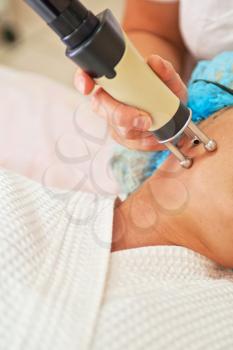 Woman getting laser face treatment in medical center, skin rejuvenation