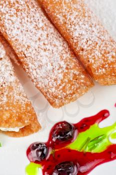 Sicilian cannoli at plate decorated with lime and jam