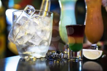 Glasses of different cocktails on bar background